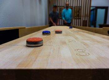 People playing shuffleboard on table