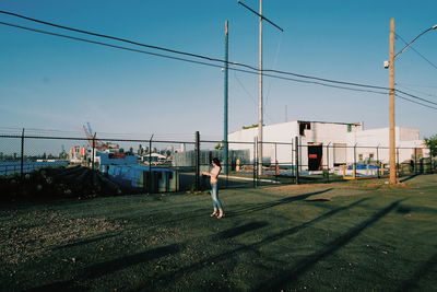 Full length of woman standing outdoors against clear sky