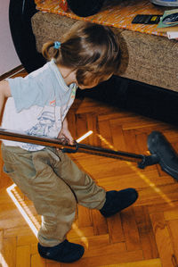 Full length of boy using vacuum cleaner on floor at home