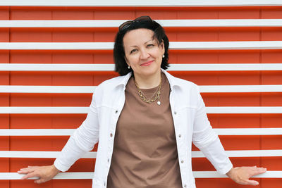 Portrait of woman standing against wall