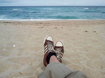 Low section of man standing on beach