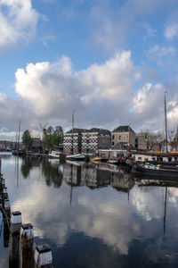 Buildings by lake against sky in city