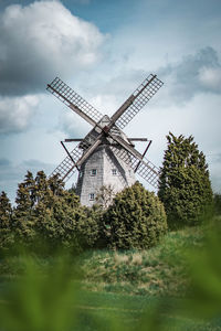 Traditional windmill on field against sky