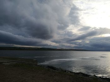 Scenic view of lake against storm clouds