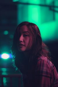 Close-up of young woman standing at night