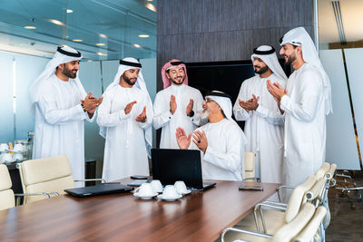 Midsection of female friends standing in office