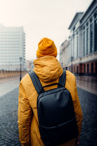 Rear view of man standing in city during winter