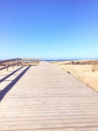 Empty road against clear blue sky