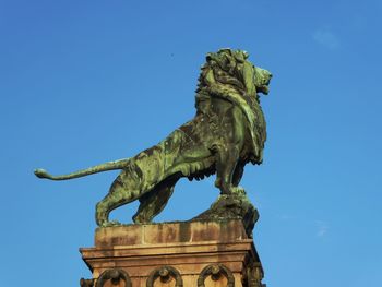 Low angle view of statue against blue sky