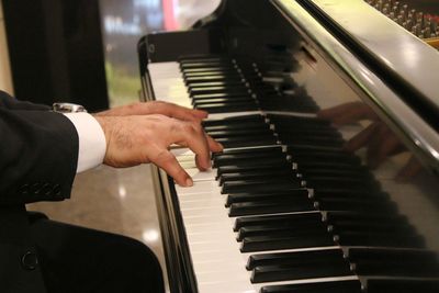 Cropped hands of man playing piano