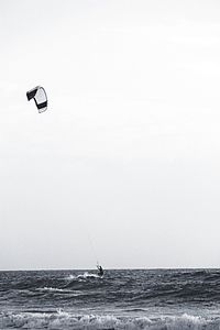 People on calm sea against clear sky