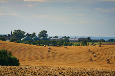 Hay bales on field against sky