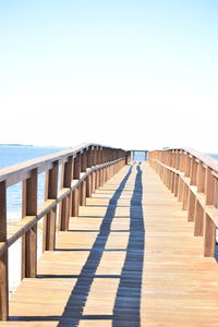 Wooden pier over sea during sunny day