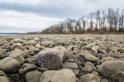 Close-up of stones on beach against sky