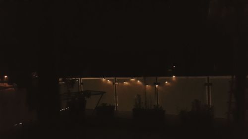 Illuminated street lights against sky at night