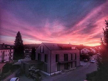 Street amidst buildings against sky during sunset