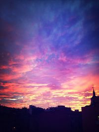 Silhouette of building against dramatic sky