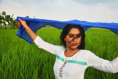 Mid adult woman standing on field against sky