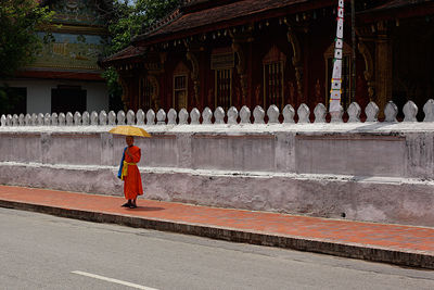 Full length of man standing outside temple against building