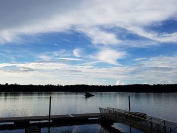 Pier on lake against cloudy sky