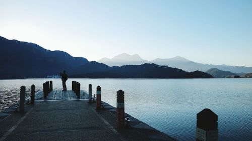 Full length of man standing on pier over river against sky