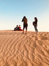 People on sand dune in desert