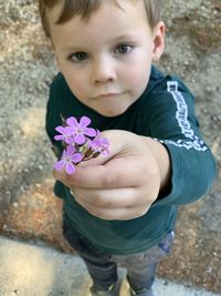High angle view of boy with purple flower