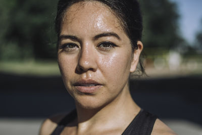 Portrait of confident woman exercising on sunny day