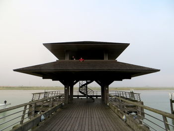 Built structure by sea against clear sky