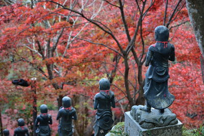 Man standing by statue during autumn