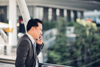 Smiling businessman talking on mobile phone in office