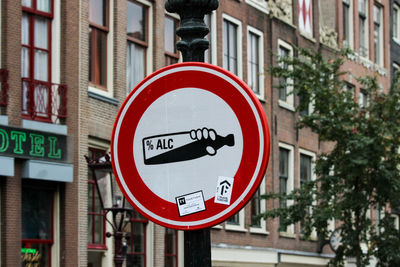 Close-up of road sign against buildings in city