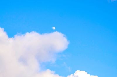 Low angle view of moon against blue sky