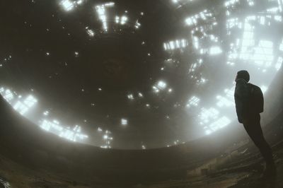 Low angle view of person standing in abandoned building against ceiling