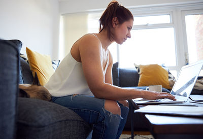 Young woman using mobile phone at home