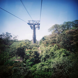 Low angle view of electricity pylon against blue sky