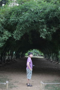 Portrait of woman standing amidst trees