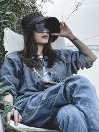 Portrait of young woman sitting in hat