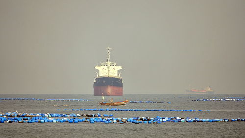 Lighthouse by sea against clear sky
