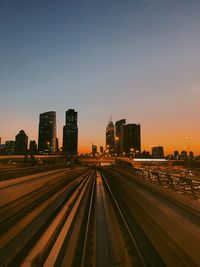 Illuminated cityscape against sky during sunset