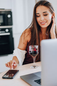 Young woman using mobile phone on table