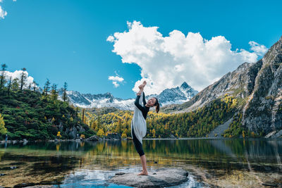 Man standing by lake against sky