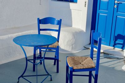 Empty chairs and table in yard