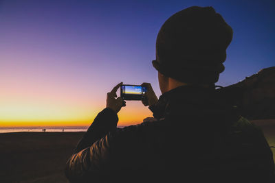 Man photographing at sunset