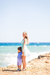 Full length of woman on beach against sky