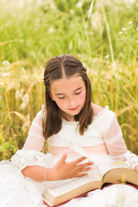 Girl reading bible in field