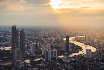 Aerial view of buildings in city during sunset