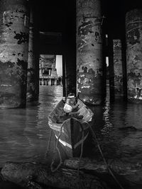 Man sitting by old building in city