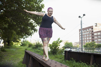 A young woman balancing on a bench