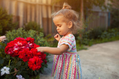 Full length of cute girl holding flowering plant